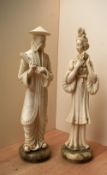 Two oriental cast composition figures depicting a male holding a scroll and a female holding a