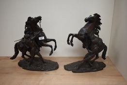 After Guilaume Couston (French 1677-1746) a pair of attractive reproduction cast patinated metal