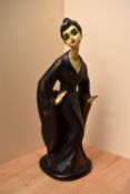 A large vintage resin figurine depicting a Geisha lady in long black dress having damage to one hand
