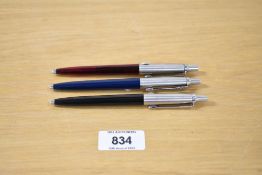 Three 1990's Parker Jotter ballpoint pens in red transparant, blue, and burgundy