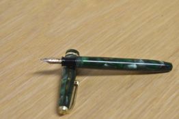 A Conway Stewart Dinkie 560 lever fill fountain pen in Green and Brown Marble with a single cap band