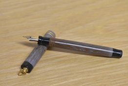 A Parker Duofold Lucky Curve button fill fountain pen in Mauve Moire with a two cap bands on a