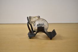 A snail form glass reservoir tilting ink well on a brass stand