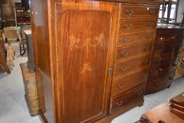 An Edwardian inlaid mahogany gentleman's wardrobe with single door enclosing the internal hanging