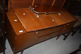 A 1960's/70's veneered dressing table, of concaved rectangular form with rectangular mirror and