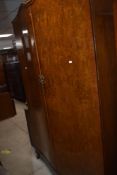 A 20th century burr walnut veneer five piece bedroom suite, comprising two wardrobes, dressing