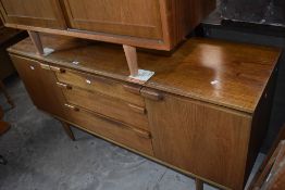 A 1960's/70's teak sideboard, of oblong form having three central drawers flanked by cupboards, on