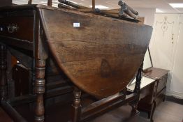 A 19th century oak drop leaf gate-legged table with demi-lune leaves and block and turned supports