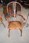 A 19th century ash and elm Windsor armchair having carved backrest and turned legs, h102cm