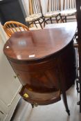 An Edwardian mahogany demi-lune pot cupboard/night stand with bow fronted cupboard and base