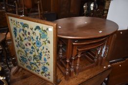 A 20th century oval nest of three table, largest w82cm, sold together with a vintage tapestry