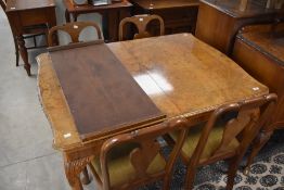 A 20th century burr-walnut extending dining table and four vase back dining chairs, with