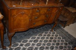 A 20th century burr walnut veneered sideboard, with an arrangement of cupboards and drawers 136cm