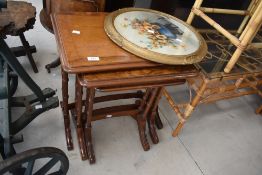 A vintage nest of tables having bamboo style legs, h55cm, sold together with a circular painting (