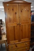 A modern pine wardrobe, of arched for with two panelled doors over two drawers 197cm x 90cm x 51cm