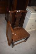 A George III oak country splat back chair with yoke-form top-rail, solid seat and square section