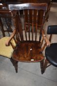 A 19th century beech and elm Windsor armchair having 'roll over' style arms, seat h46cm x back