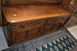 A 20th century oak sideboard, of oblong form with canted front corners , carved drawer fronts and