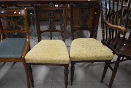 A pair of 19th / early 20th century chairs having carved back, upholstered seat and turned legs,