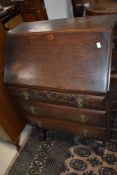 A 1940's oak bureau, of traditional design with three drawers 99cm high