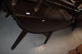 An Ercol type dark elm drop-leaf dining table, with moulded legs and x-form stretcher 73cm x 104cm x