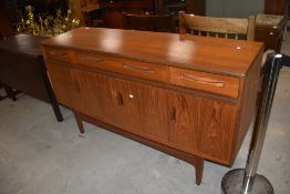 A mid-century G-Plan 'Fresco' sideboard having three drawers and four cabinet doors, L153cm