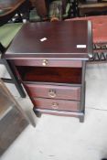 A vintage Stag minstrel two drawer bedside raised on tapering legs, designed by John and Sylvia