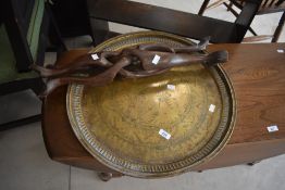 A vintage brass top side table raised on intertwined wooden legs, table top width 55cm