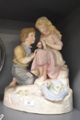 An early 20th century German painted ceramic figure of a boy and girl, h37cm