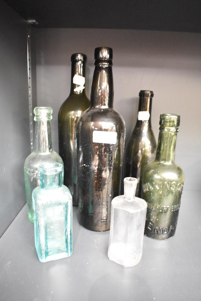 Seven vintage green glass and advertising bottles including a Wilkinson's Collin Croft Brewery