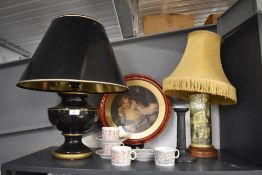 A large black and gilt urn form lamp with matching shade (some damage to shade), four hand painted