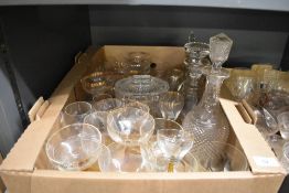 A cut glass biscuit jar, three cut glass decanters, and a selection of assorted spirit glasses in