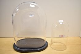 A 20th century glass display dome with rounded rectangular base, 32cm sold along with another