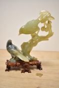 A Chinese style jade/ hard stone bird sculpture raised on a wooden base, h21.5