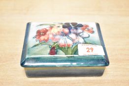 A Moorcroft pottery trinket with cover, decorated with floral patterns, L12cm