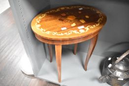 A reproduction inlaid musical sewing table, in the Continental style of hinged oval form top