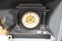 A 19th century black 8 day mantel clock having black Roman numerals on an enamelled chapter ring