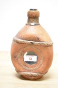 A liquor bottle wrapped in leather and containing coins, h20.5cm