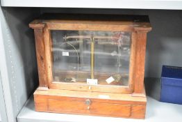 An early 20th century Becker's & Son balance scale held within a wooden and glass case, h33cm
