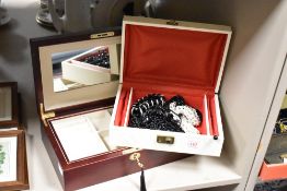 A faux leather cream jewellery box, containing a small collection of costume jewellery, along with a