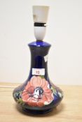 A Moorcroft pottery table lamp decorated with floral patterns on a colbert blue ground, h27cm