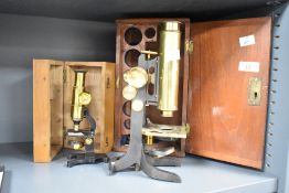 A brass microscope housed in a fitted wooden box, h26cm, sold together with 1 other