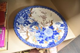 An early 20th century Chinese charger decorated with birds and cherry blossom, impressed and painted