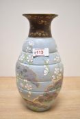 A Doulton & Slaters pottery vase hand painted with floral patterns on a blue ground, h25cm
