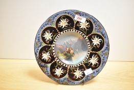 A 19th century Hubert Sattler pottery charger, the centre hand painted depicting a Swiss landscape