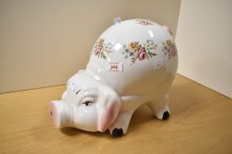 A large pottery Piggy Bank, decorated with foliate sprays with coin slot to surmount, 24cm high