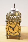 A Smiths brass mechanical lantern clock, having a domed bell top with engraved circular dial and