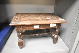 An Edwardian carved oak stool/stand, of rectangular form with stylised foliate carving to the