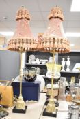 A pair of brass lamps having fabric shades and raised on a square base, h97.5cm
