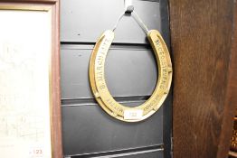 A brass horse shoe having impressed mark for Mr Geo, Stevens Decoration Committee 8, March 1877,